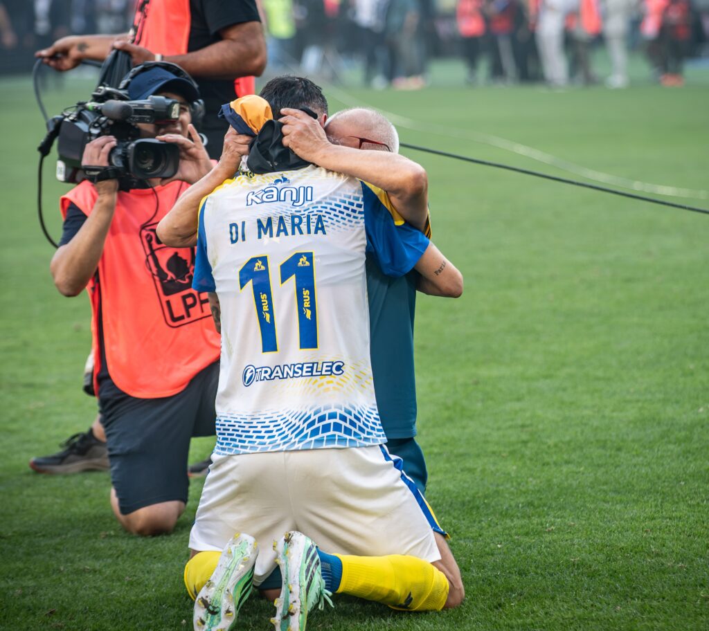 Ángel Di María de espaldas con la camiseta 11 de Rosario Central, arrodillado y abrazado en el césped tras ganar la Supercopa