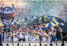 El plantel de Rosario Central celebra en el podio de campeón de la Supercopa Internacional con papelitos y paraguas azul y amarillo
