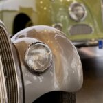 Detalle de la trompa y el faro de un auto clásico en una exposición