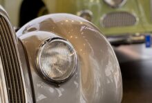 Detalle de la trompa y el faro de un auto clásico en una exposición