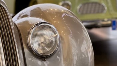 Detalle de la trompa y el faro de un auto clásico en una exposición