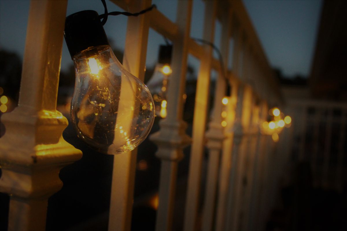 Una guirnalda de luces cálidas en la baranda cambia el balcón de noche