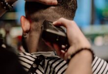 Barbero haciendo un corte degradado con máquina a un hombre