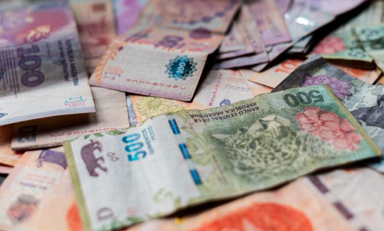 Billetes de pesos argentinos de distintas denominaciones sobre una mesa