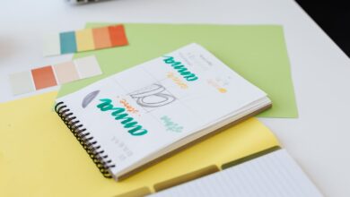 Cuaderno con bocetos de diseño de logo y muestras de color sobre un escritorio