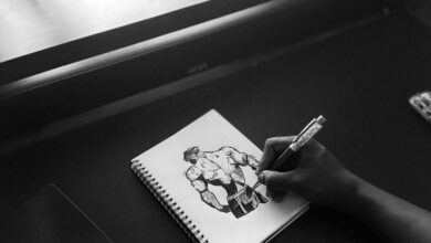Persona dibujando un personaje de historieta en blanco y negro sobre un cuaderno