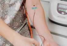 Profesional de la salud con guantes durante una extracción de sangre en el brazo de un paciente