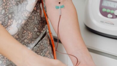 Profesional de la salud con guantes durante una extracción de sangre en el brazo de un paciente