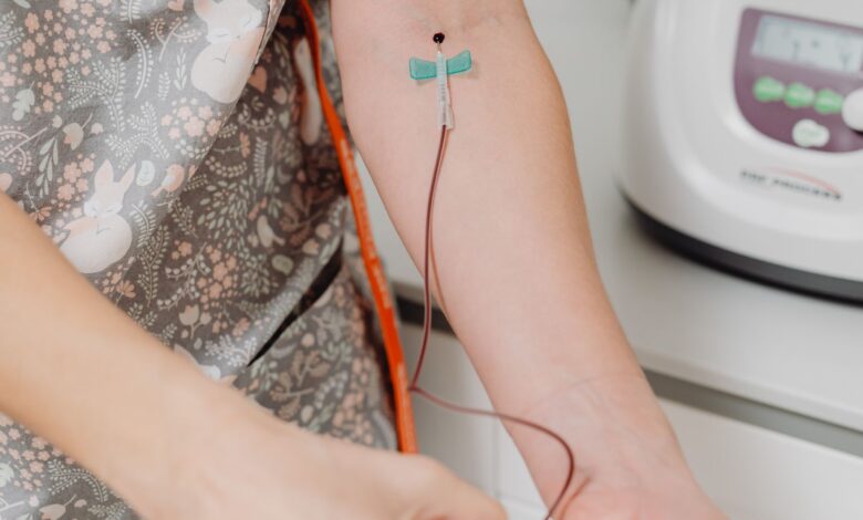 Profesional de la salud con guantes durante una extracción de sangre en el brazo de un paciente