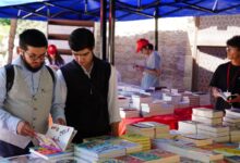 Personas recorriendo mesas con libros en una feria del libro