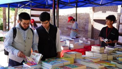 Personas recorriendo mesas con libros en una feria del libro