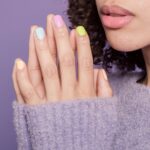 Manos de mujer con uñas pintadas en tonos pastel