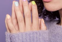 Manos de mujer con uñas pintadas en tonos pastel