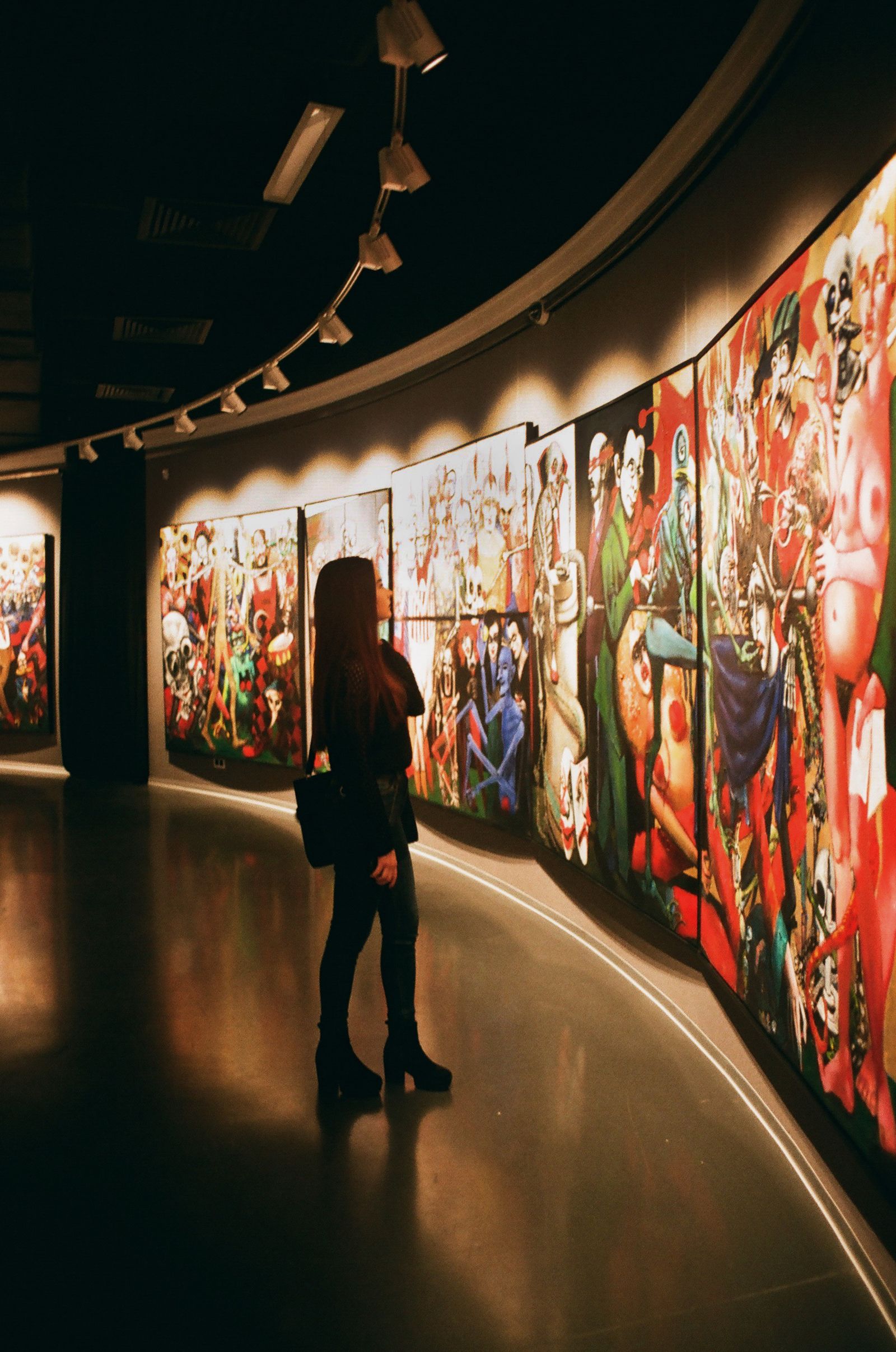 Mujer observa pinturas en una galería de arte