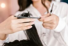 Peluquera cortando el pelo largo de una clienta en un salón