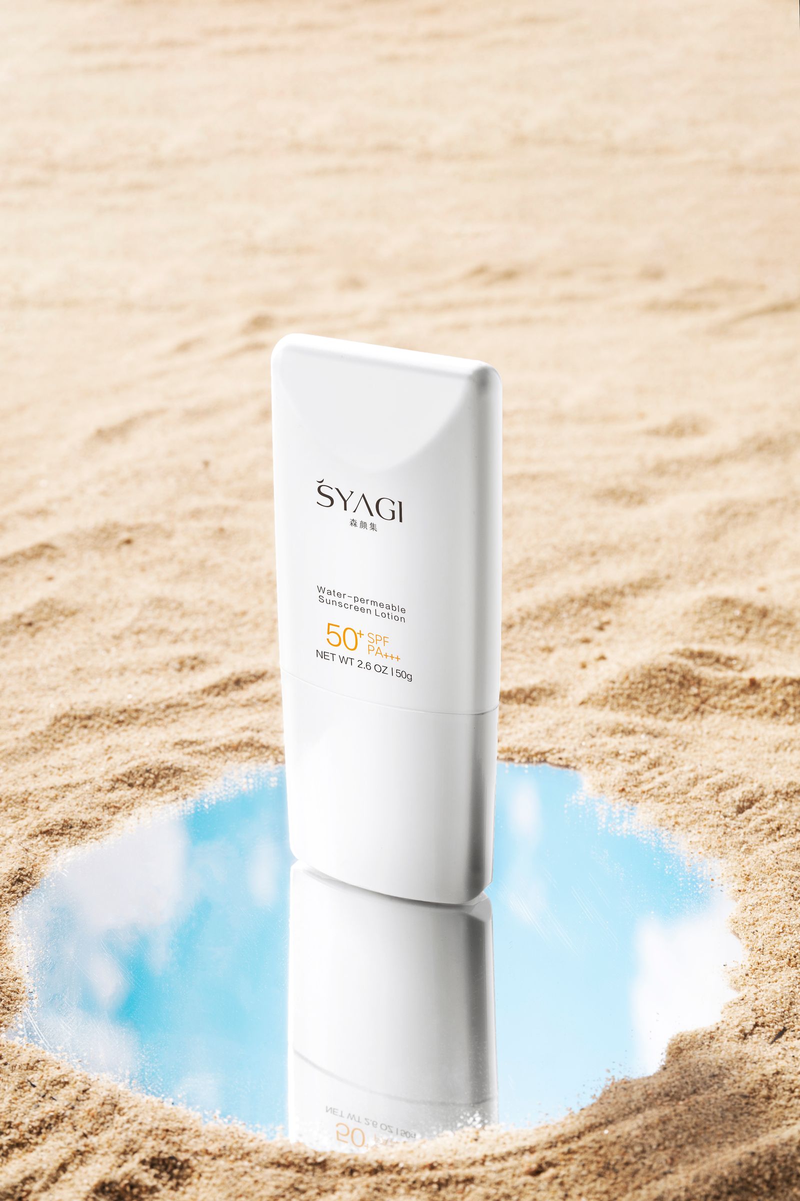 Envase de protector solar FPS 50 apoyado sobre la arena