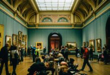 Visitantes recorriendo una galería de arte con pinturas