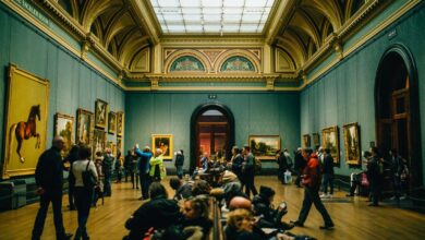 Visitantes recorriendo una galería de arte con pinturas
