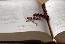 Rosario de cuentas rojas sobre una Biblia abierta