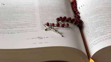 Rosario de cuentas rojas sobre una Biblia abierta