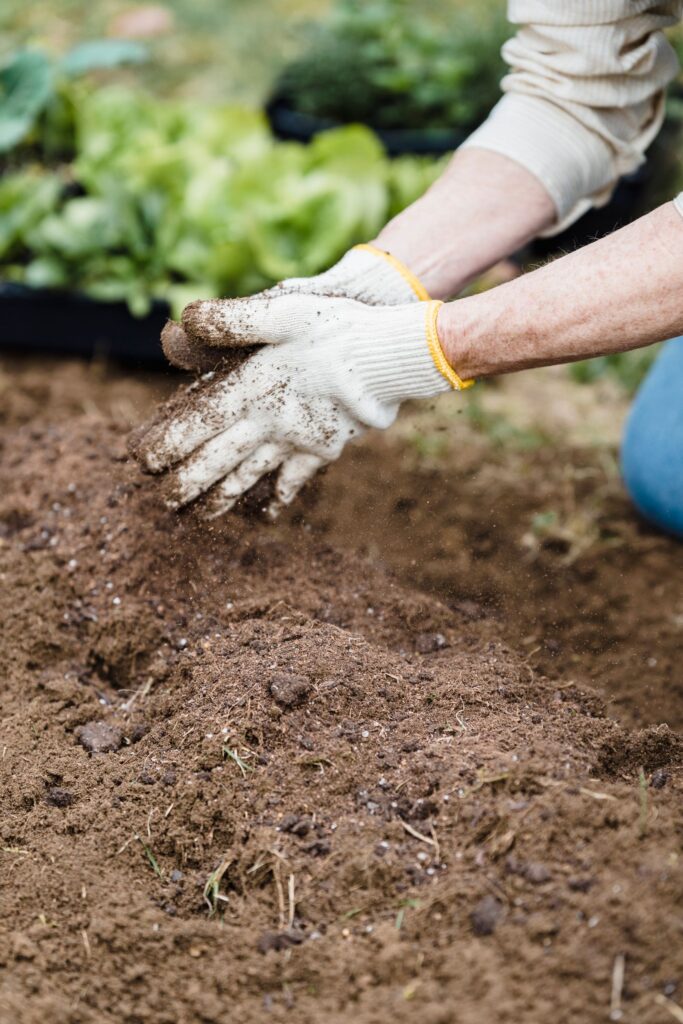 Persona trabajando la tierra con herramientas de jardinería