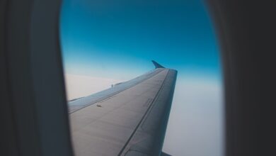 Vista del ala de un avión desde la ventanilla, sobre el cielo