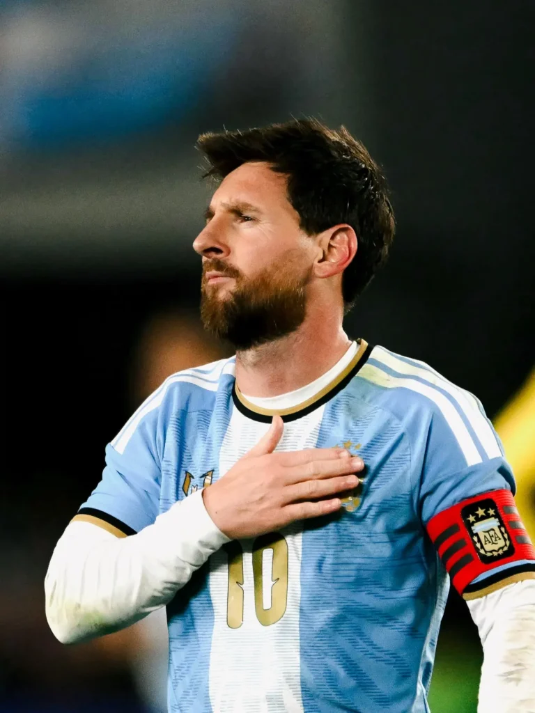 Messi con la mano derecha sobre el escudo de la camiseta y la cinta de capitán en el brazo, durante el saludo final.