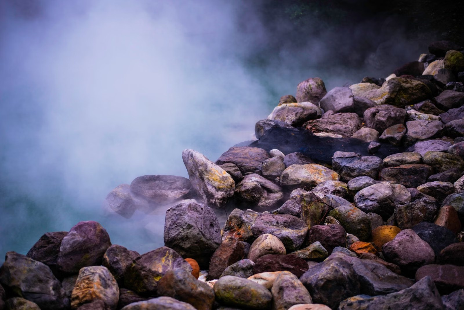 Vapor saliendo de aguas termales entre piedras