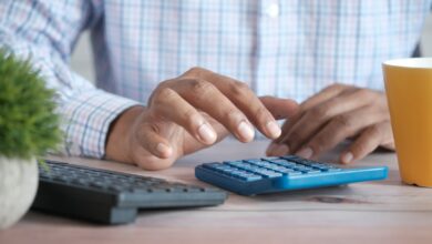 Persona usando una calculadora en el escritorio
