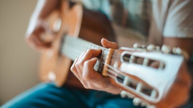 Manos tocando una guitarra criolla