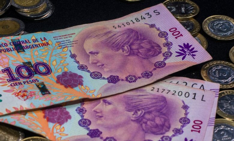 Billetes y monedas de pesos argentinos sobre una mesa