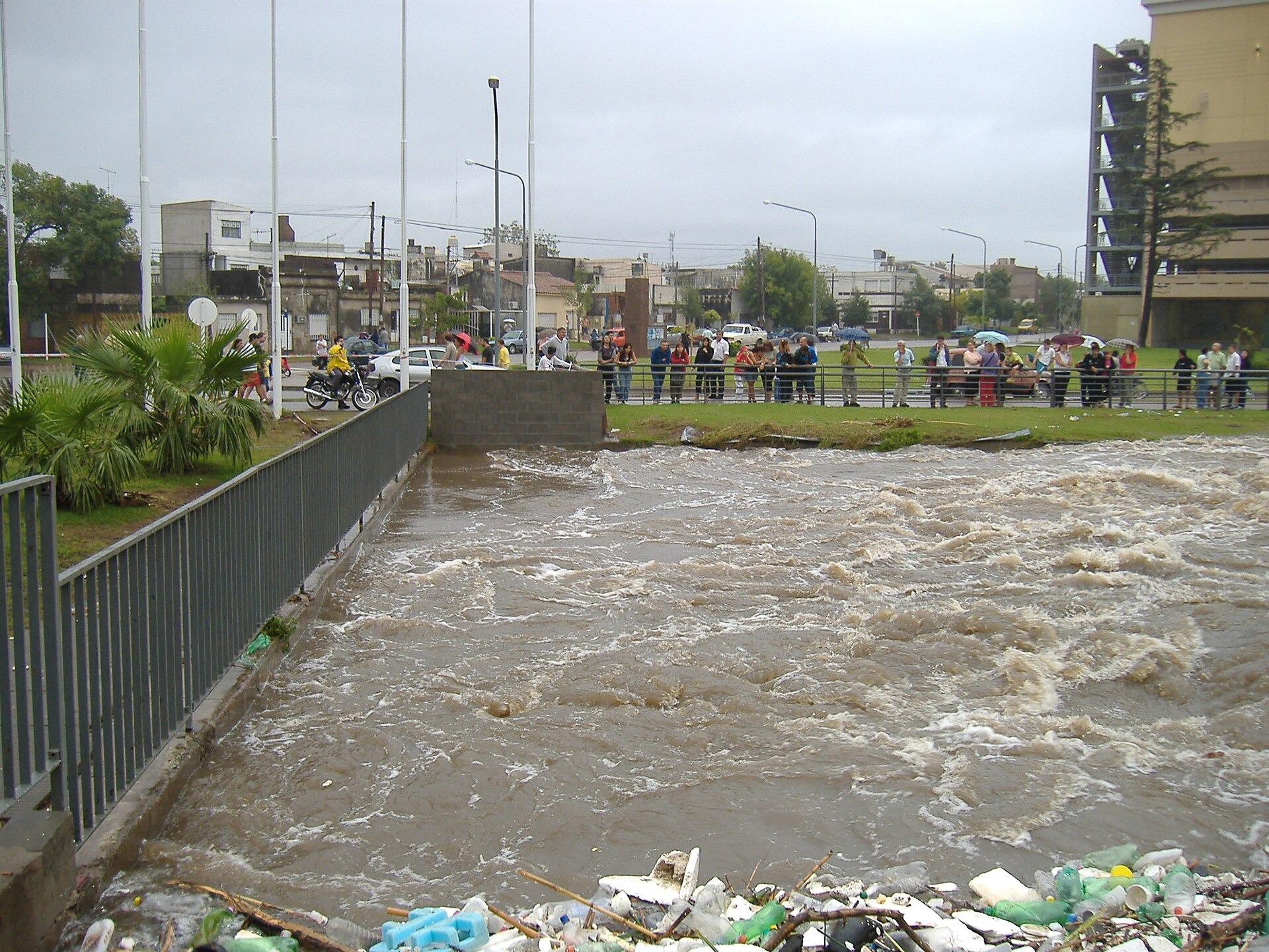 El arroyo Ludueña con caudal alto a su paso por Rosario, junto a la baranda de la costanera