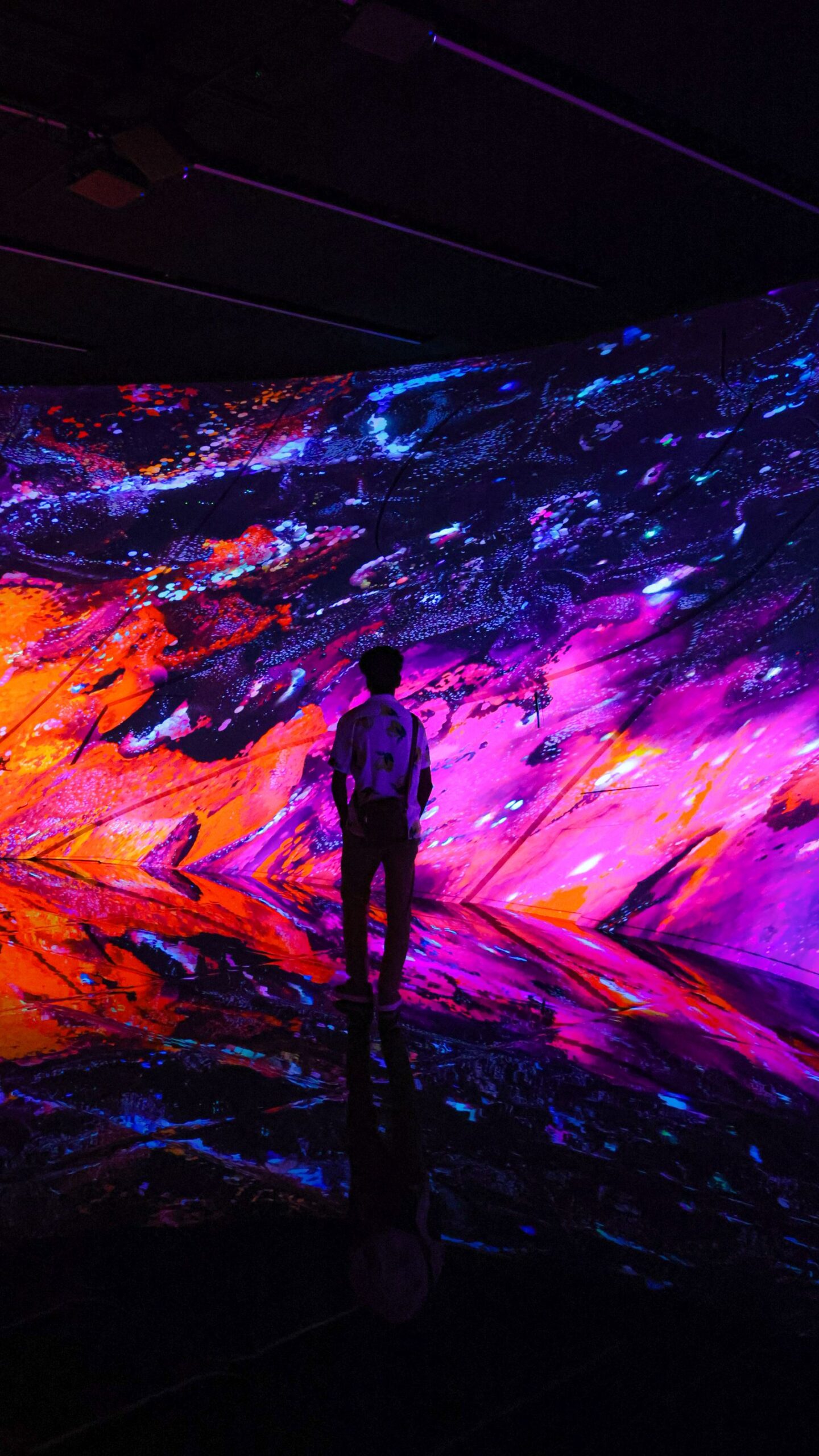 Persona frente a una proyección de arte digital de colores intensos