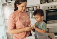 Madre y su hijo preparando algo juntos en la cocina de su casa
