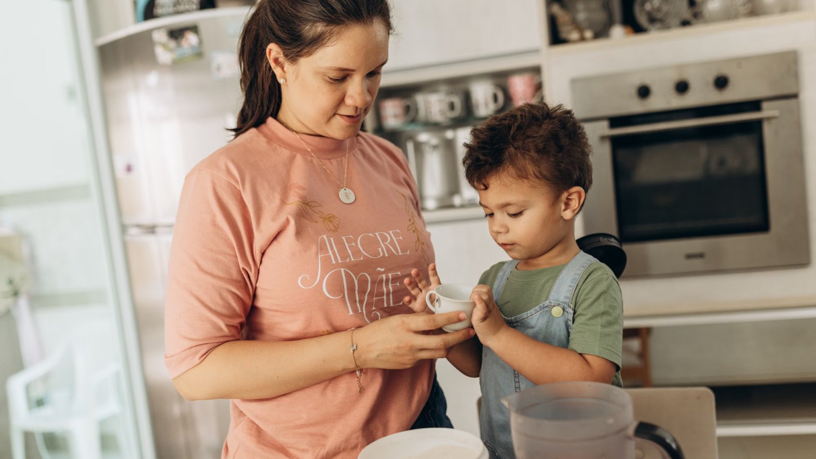 Madre y su hijo preparando algo juntos en la cocina de su casa