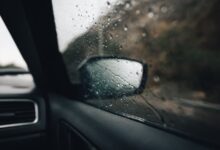 Gotas de lluvia sobre la ventanilla y el espejo lateral de un auto durante una tormenta