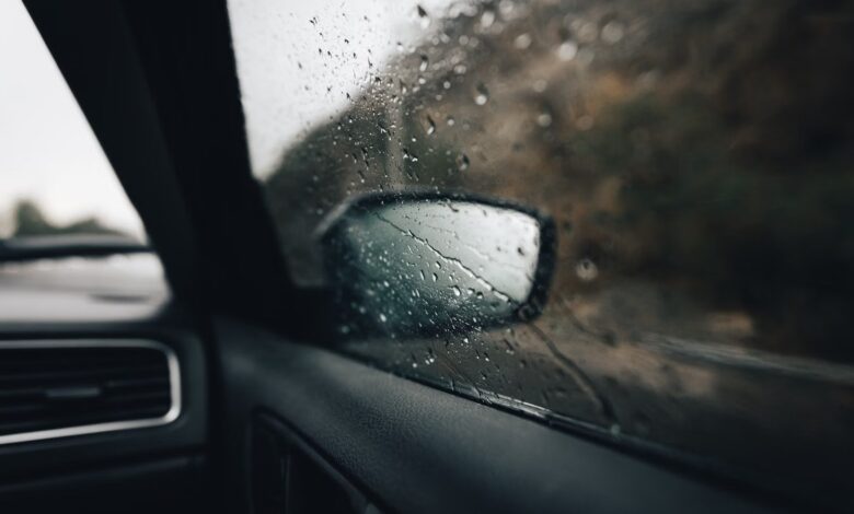 Gotas de lluvia sobre la ventanilla y el espejo lateral de un auto durante una tormenta