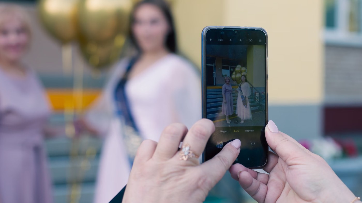 Manos sosteniendo un celular mientras sacan una foto