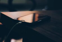 Celular conectado al cargador sobre una mesa de madera