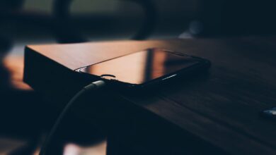 Celular conectado al cargador sobre una mesa de madera