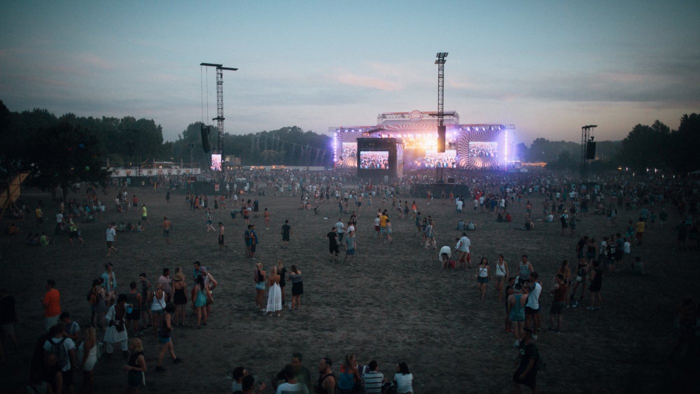 Escenario iluminado al atardecer en un festival