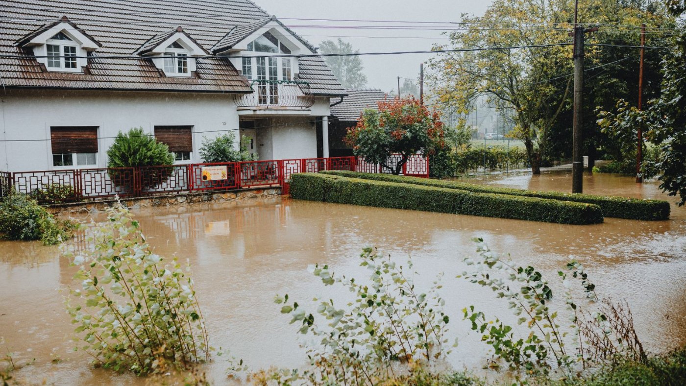 Casa con el jardín y la calle cubiertos de agua marrón