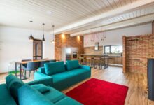 Living moderno con paredes de ladrillo, sillón verde y alfombra roja
