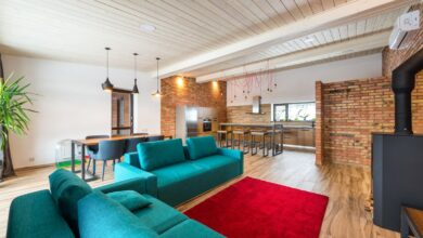 Living moderno con paredes de ladrillo, sillón verde y alfombra roja