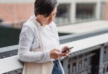 Mujer usando su celular en un balcón