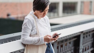 Mujer usando su celular en un balcón