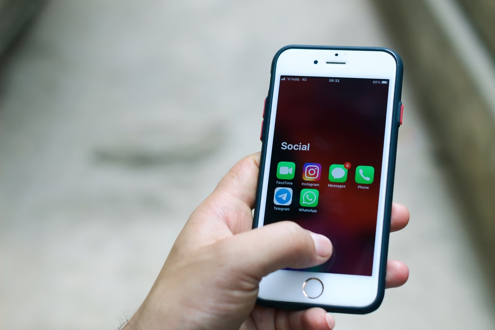 Mano sosteniendo un celular con las aplicaciones de mensajería en la pantalla