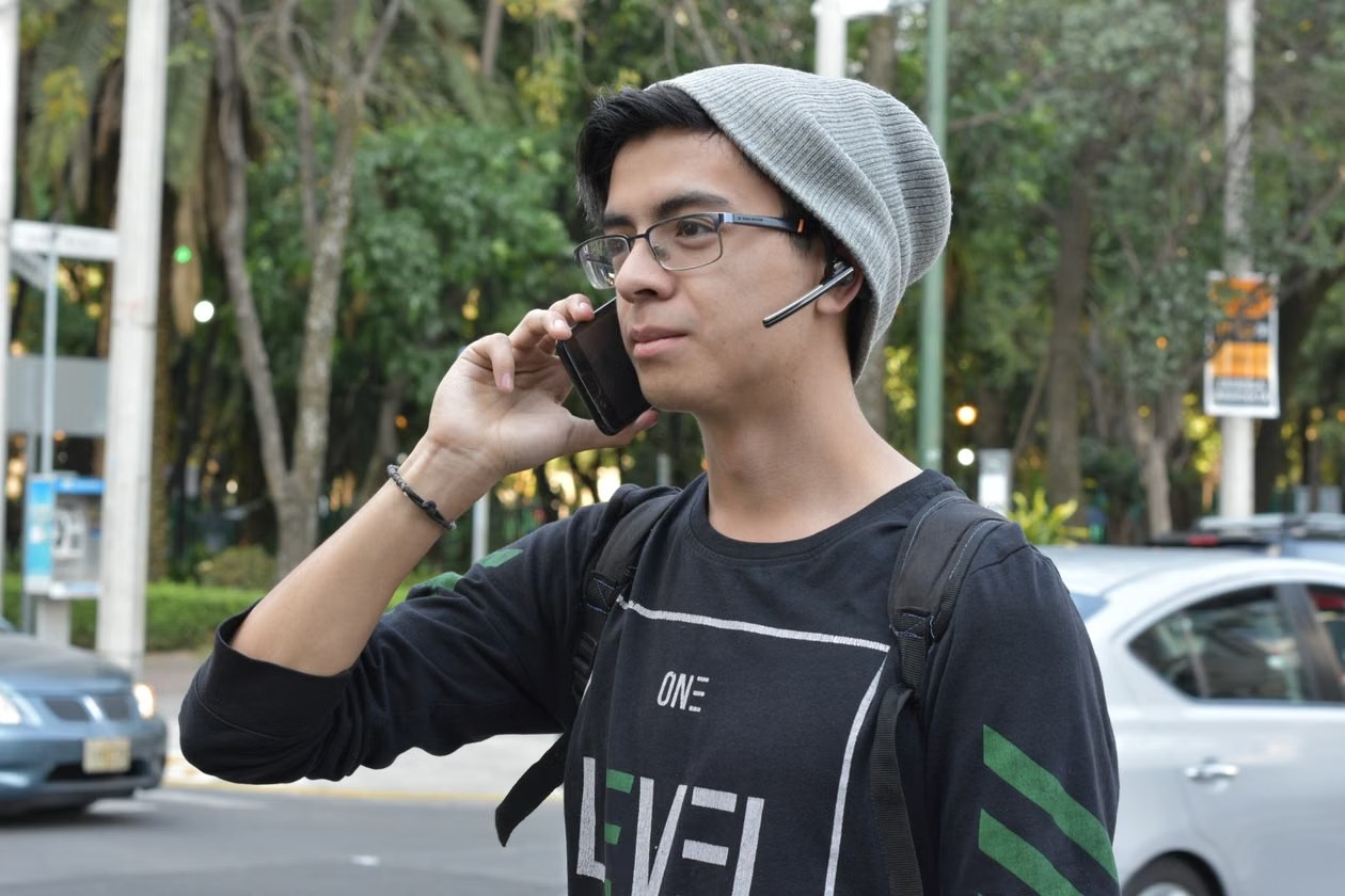 Joven hablando por celular en una calle de la ciudad