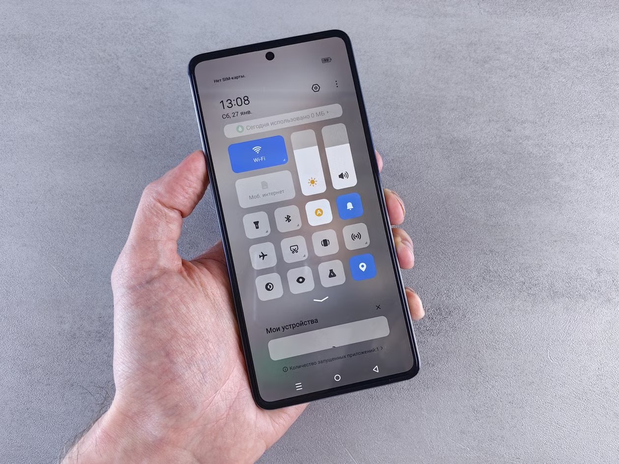 Mano sosteniendo un celular con el menú de ajustes abierto