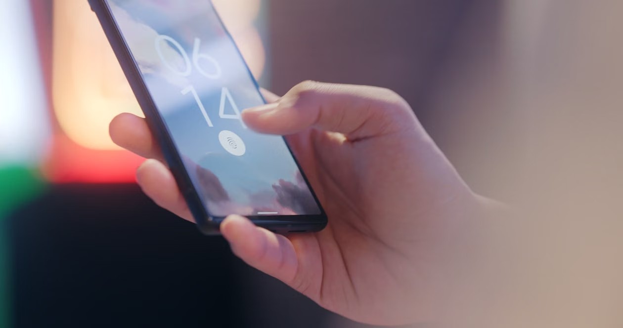 Mano sosteniendo un celular bloqueado con sensor de huella dactilar